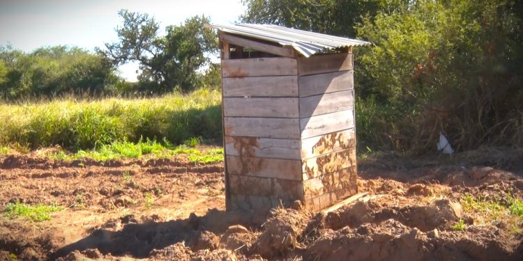 En Yalve Sanga, las letrinas de madera persisten aún en escuelas aldeanas mientras aguardan «Letrina Cero»
